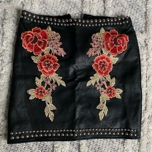 Embroidered leather mini skirt.